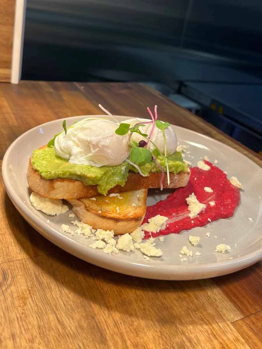 Smashed avocado on sourdough with two poached eggs, beetroot hummus and feta