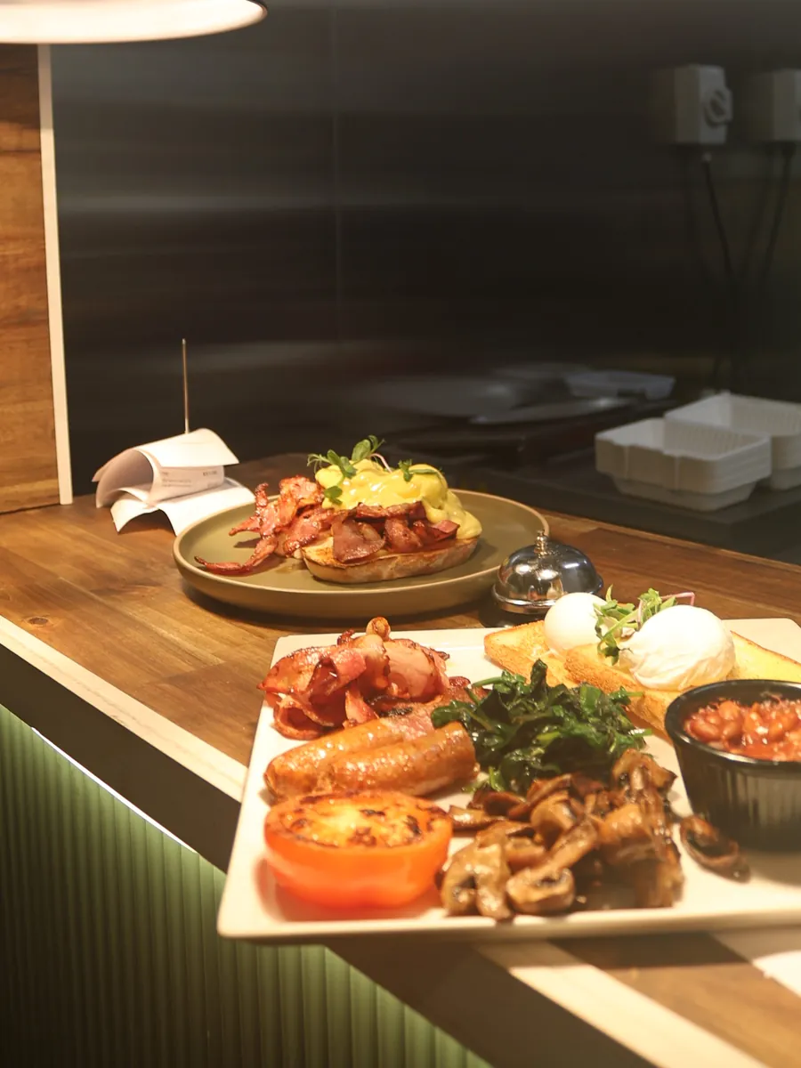 A big breakfast with bacon, sausage, mushrooms, tomato, beans and poached eggs