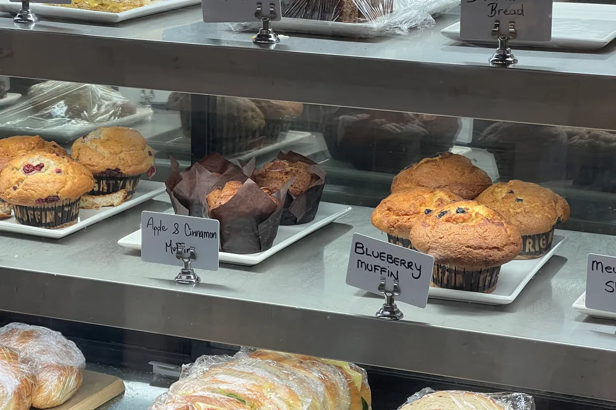 The cabinet with muffins, carrot cake, banana bread and fresh sandwiches