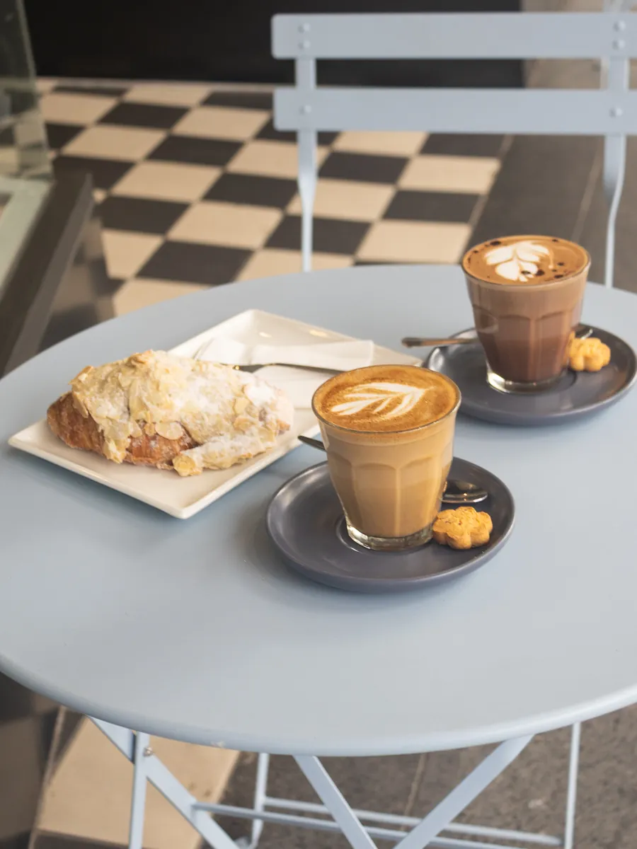 A flat white and a croissant on a table at Jardine’s