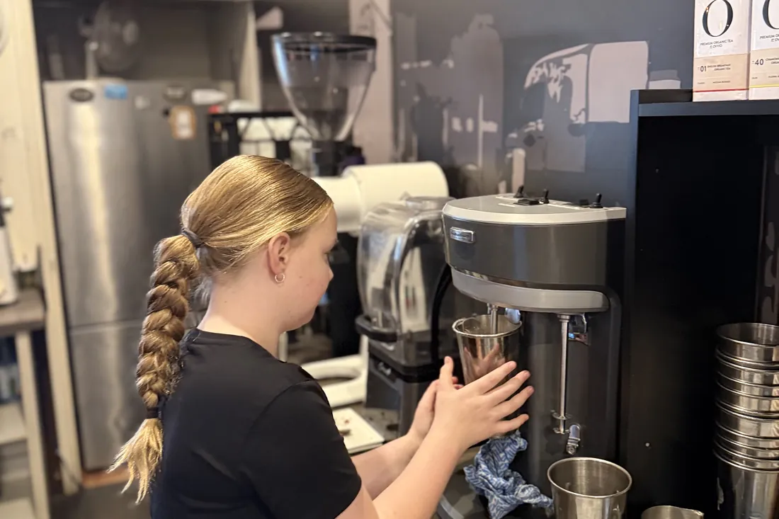 A team member making a milkshake behind the counter