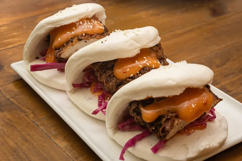 Three bao buns with fried chicken and pickled cabbage