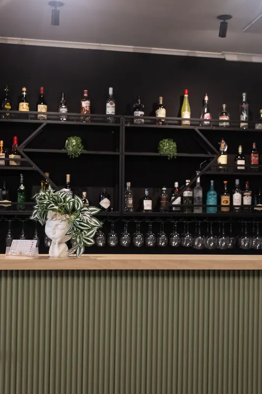 The bar, with spirits on the shelves and glasses below