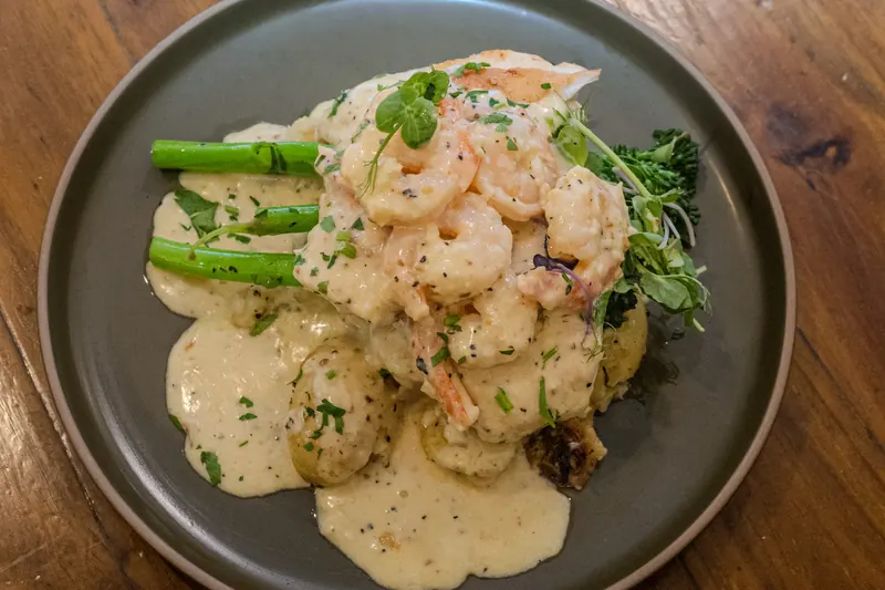 Chicken breast with creamy garlic prawn sauce, potatoes and broccolini