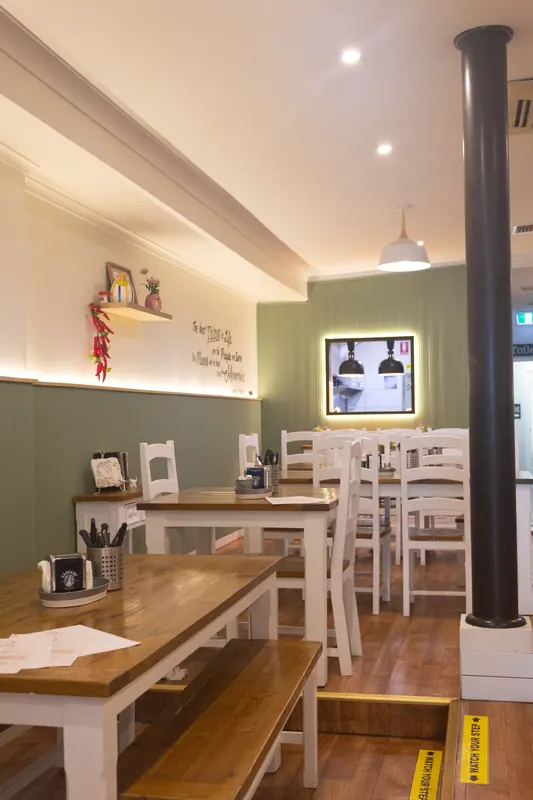 Tables along the green wall, with the bar beyond