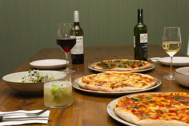 Pizzas, pasta and wine on a table